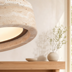 Travertine stone pendant light casting a soft warm glow in a dining room