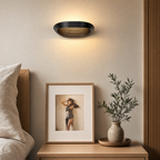 Black geometric wall sconce mounted in a hallway