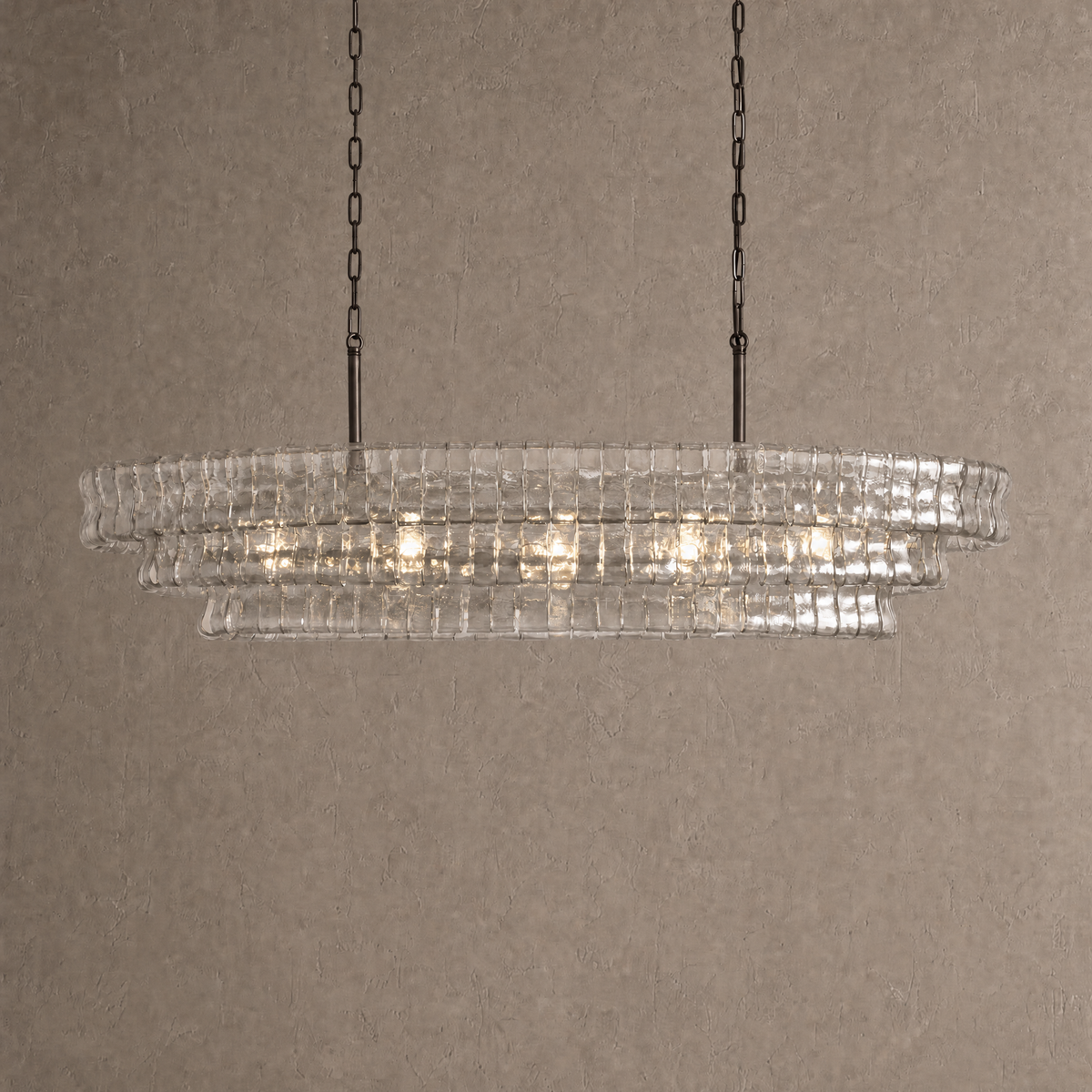Ghiaccio oval chandelier in clear ribbed glass with dark bronze chains and rods