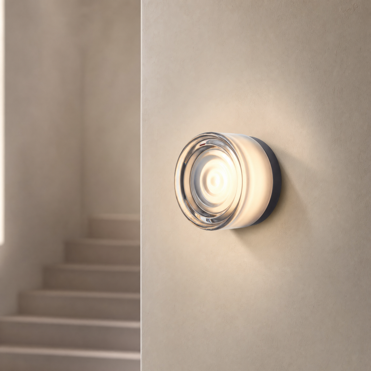 Vela modular wall sconce in Smoke Wave lighting an elegant staircase wall