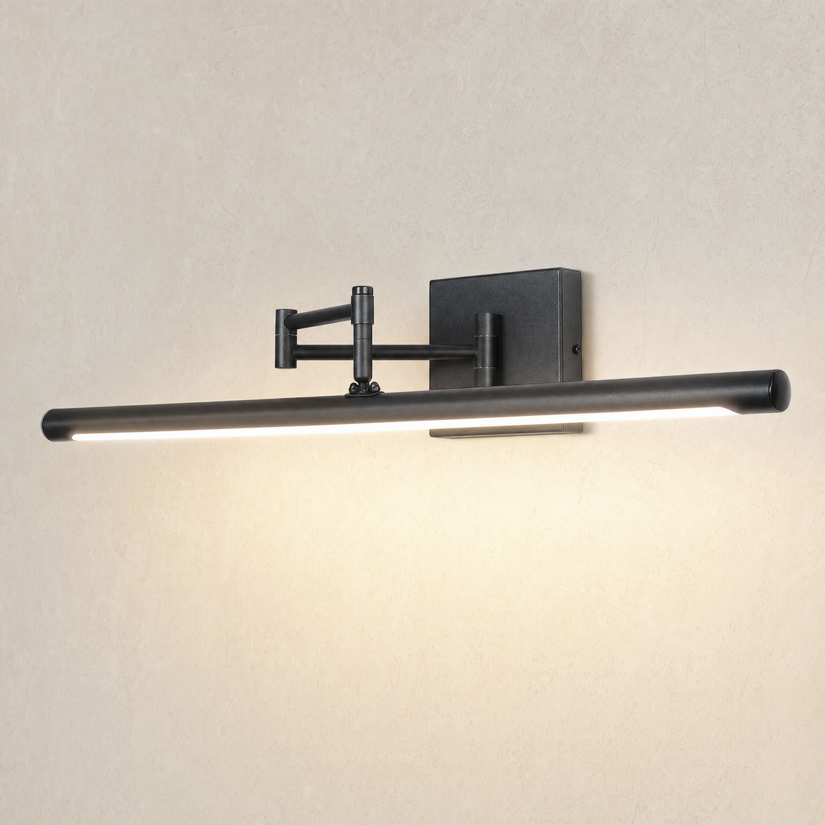 Black swing arm LED vanity light switched on, casting a warm glow